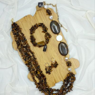 A set consisting of a necklace, earrings, and bracelet made of Tiger's Eye stones .