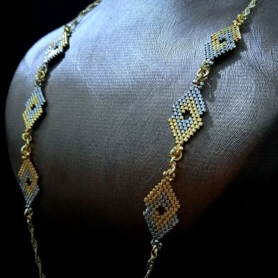A necklace with geometric designs in gold and silver, made from Miyuki beads.