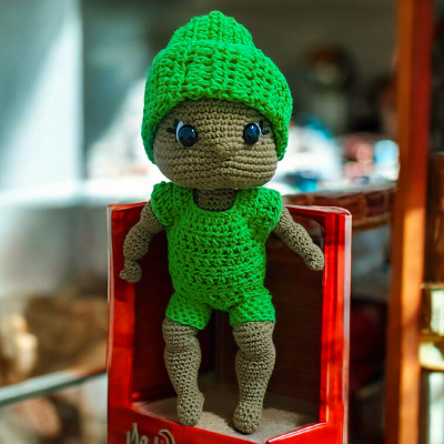 دمية كروشيه بقبعة خضراء