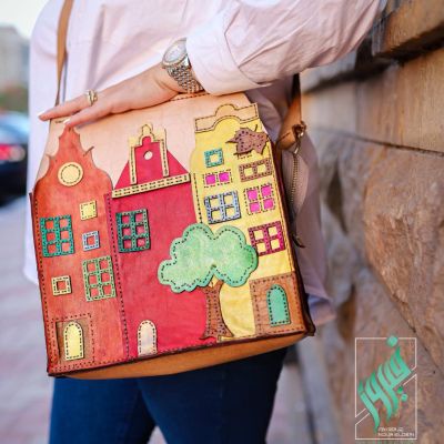 A natural leather bag with colorful houses on it