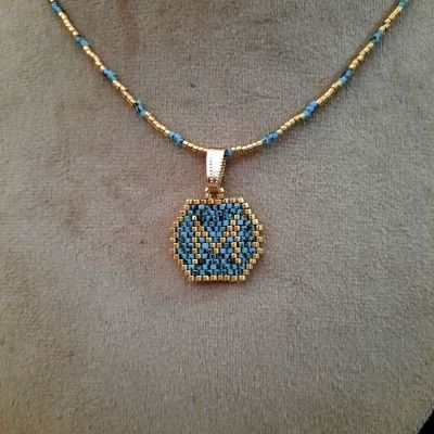 A necklace with a letter design by Miyuki beads