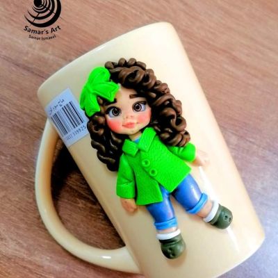 مج حراري مُزَيَّن بدُمية مصنوعة من الصلصال الحراري