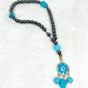 A prayer necklace made from hematite stones, with turquoise spacers.